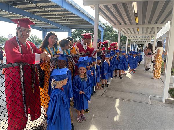 17 high school seniors who “graduated” from Shore Aces Elementary 7 years ago and current K - 4th graders clapped for the 5th-grade class as they walked the halls for the last time.